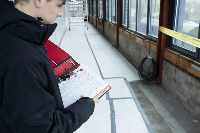 Un surveillant expérimenté prend des notes à côté d'une zone de travail balisée