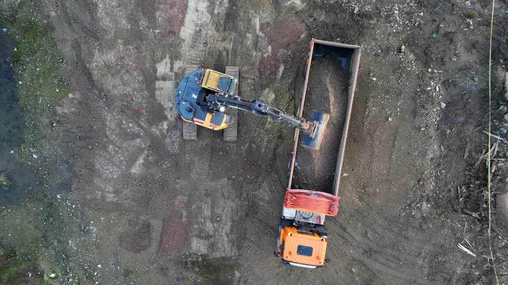 Assainissement du sol à la pelleteuse et au camion